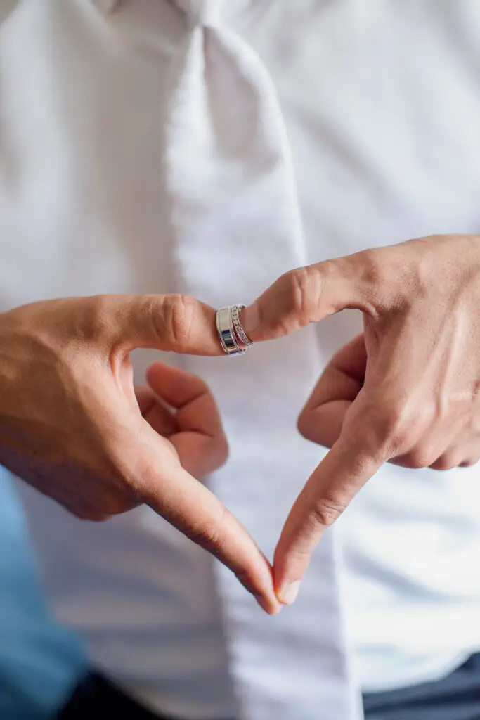Romantic groom photo with wedding bands in heart formation