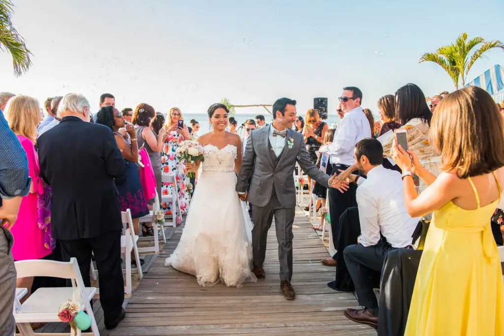 Newlyweds walking down the aisle after ceremony at Crescent Beach Club