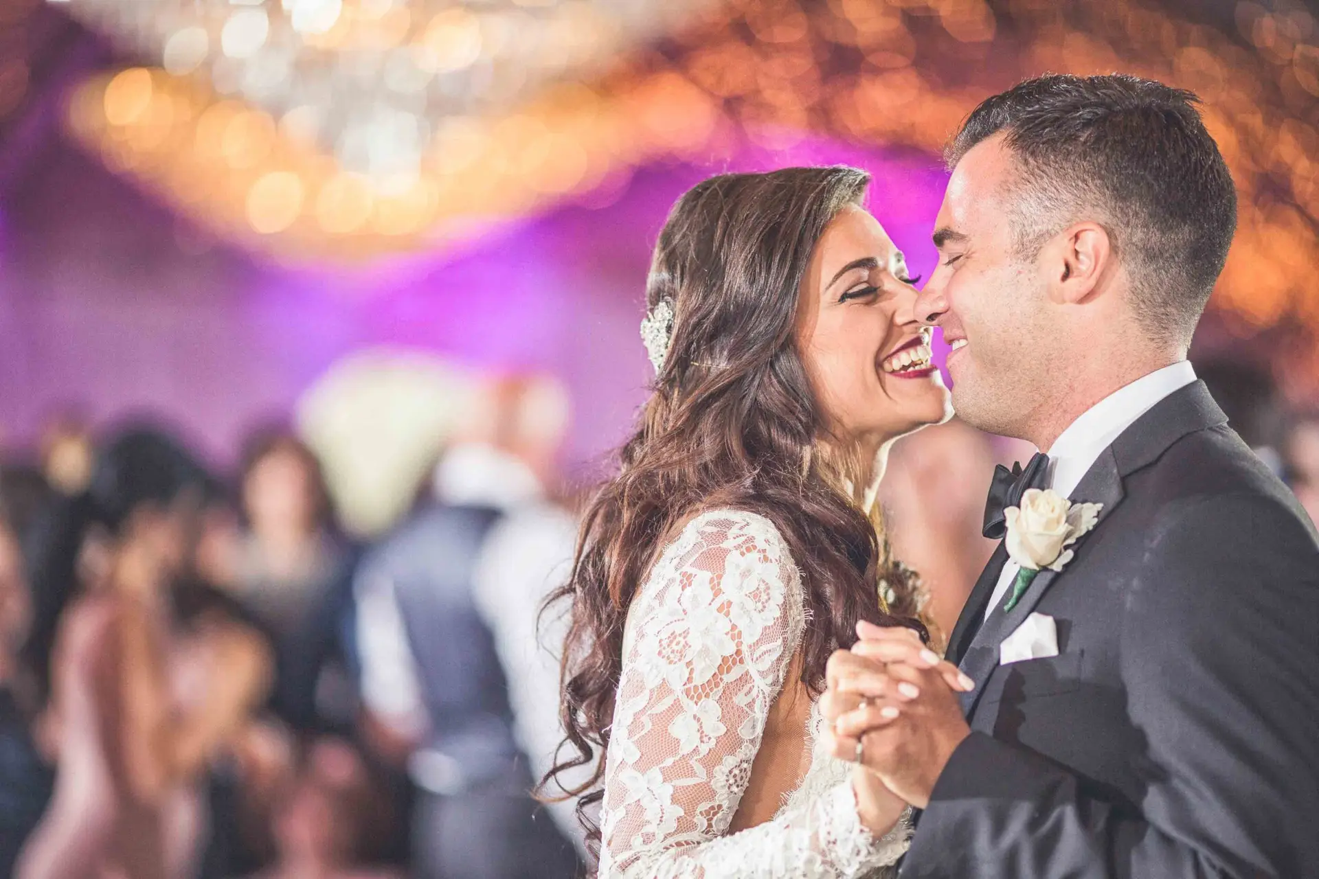Bride and groom share a romantic first dance, gazing at each other with love and joy on their wedding day.