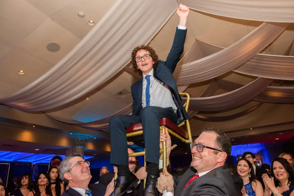 Mitzvah boy lifted on chair during Hora dance