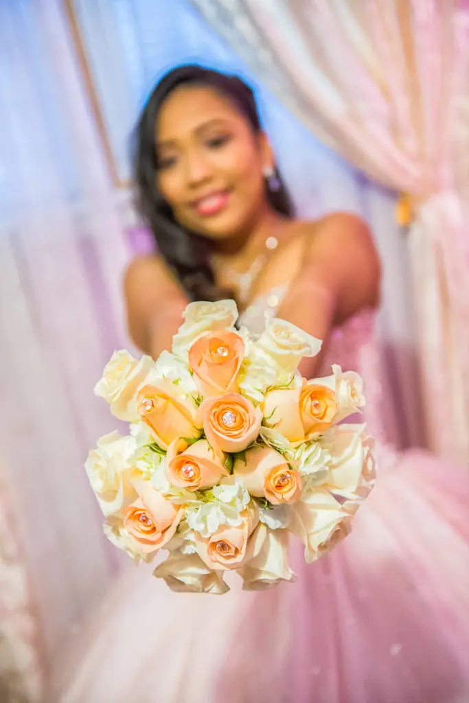 Quinceañera holding her bouquet with a radiant smile