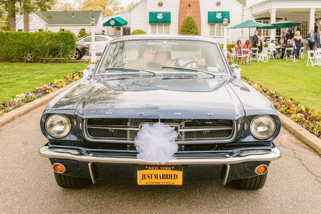 Bride and groom’s romantic exit in a classic Mustang