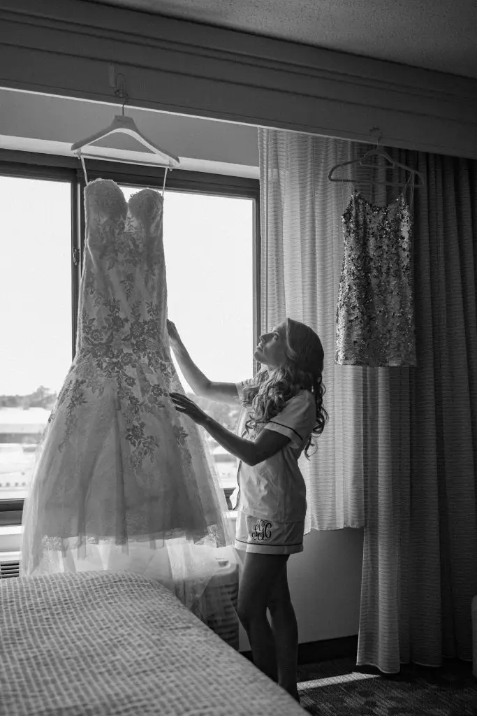 Bride admiring wedding dress before getting ready