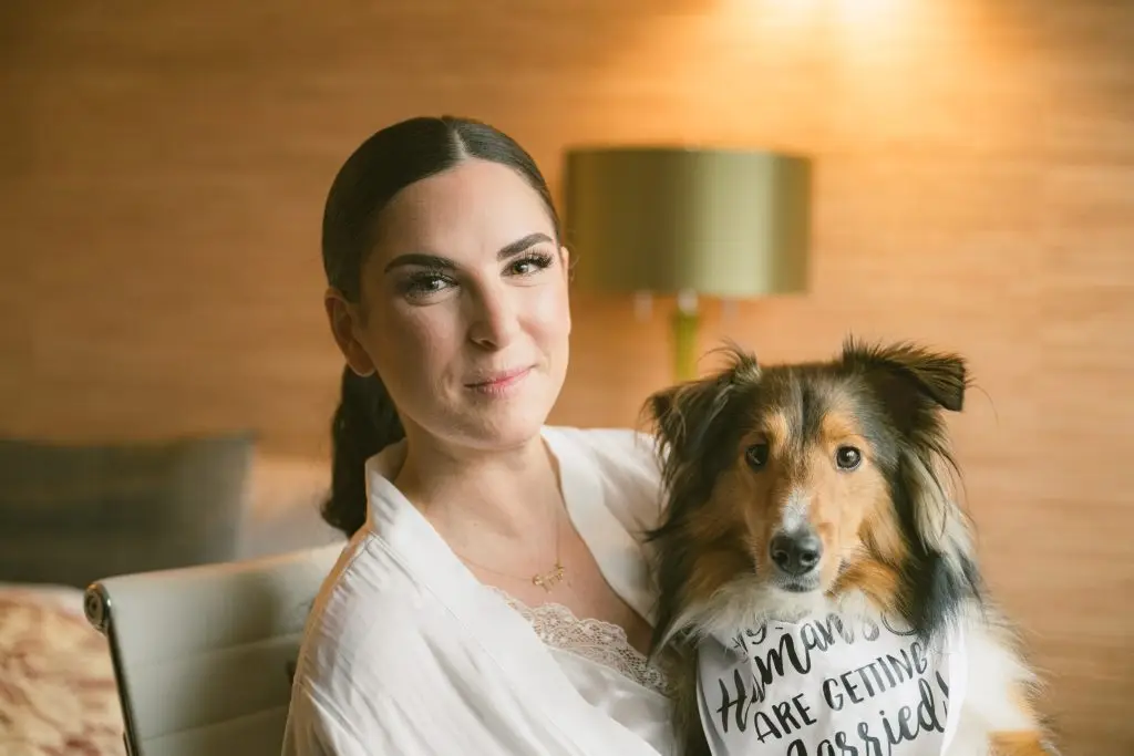 Bride sharing a moment with her dog before wedding at 48 Wall Street, NYC​