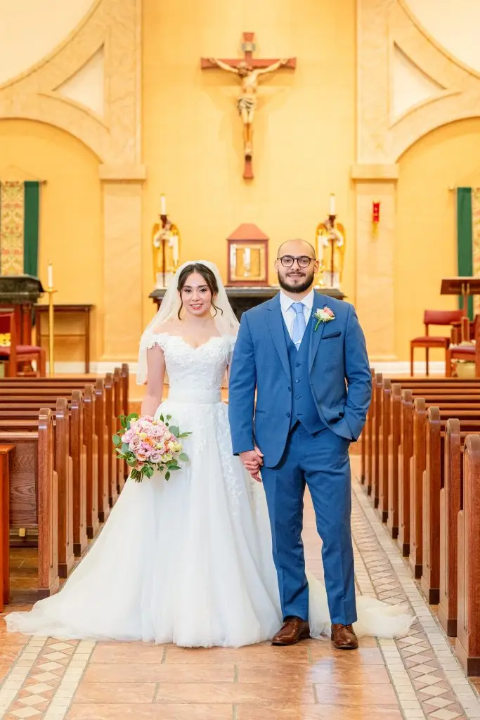 Bride and groom holding hands in church aisle after wedding