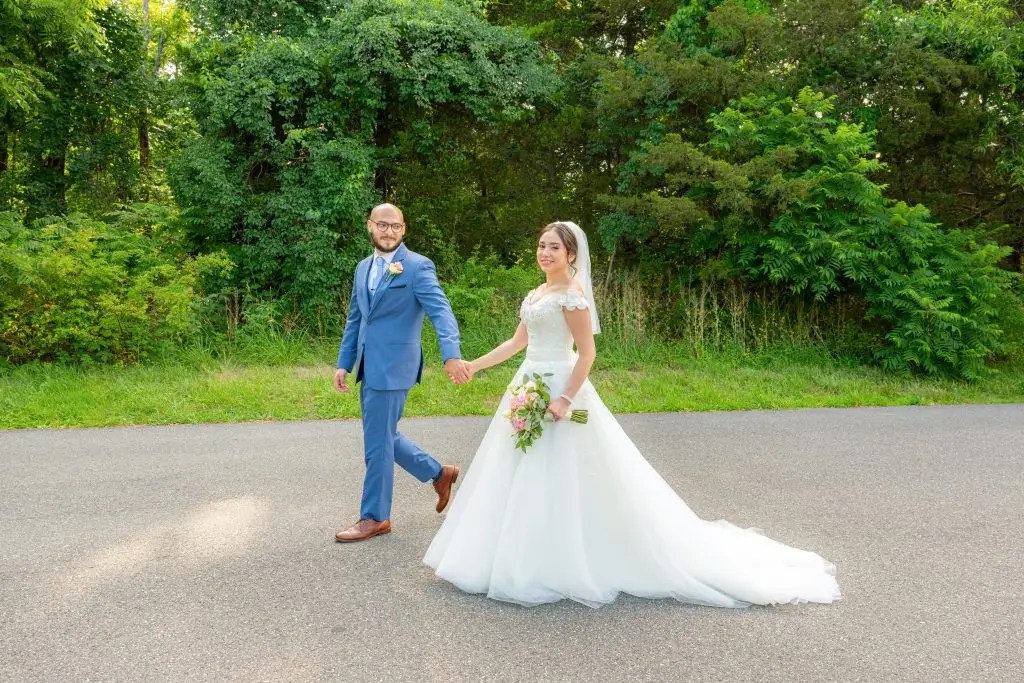 Just married couple holding hands and walking joyfully