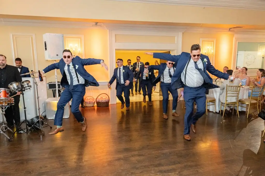 Groomsmen making a fun and stylish grand entrance at wedding reception