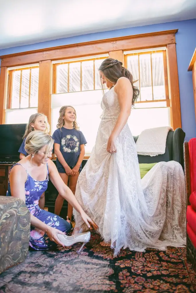 Maid of honor helping bride put on shoes at The Hill, Hudson