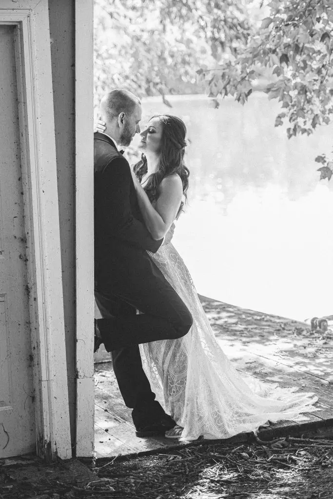 Black and white photo of bride and groom near the pond at The Hill, Hudson, NY​