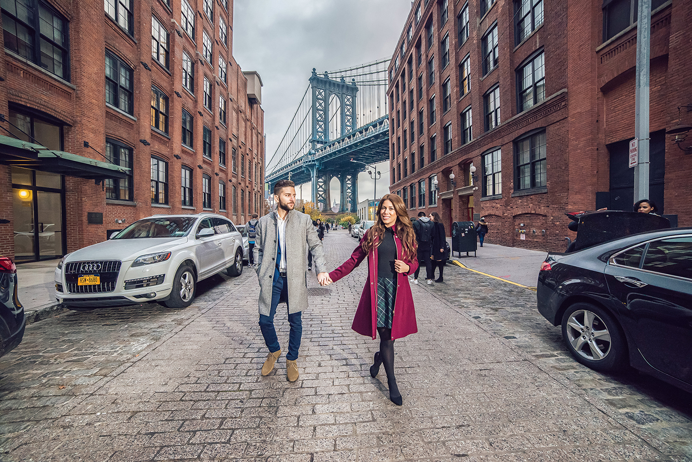 Long Island wedding photographer capturing a natural engagement session under the Brooklyn Bridge in DUMBO