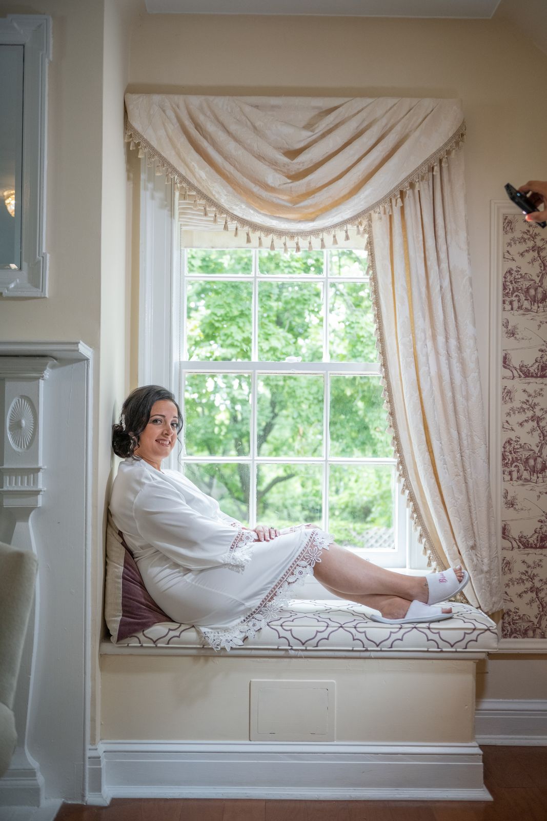 Bride relaxing on a window seat before the ceremony at The Royalton Mansion