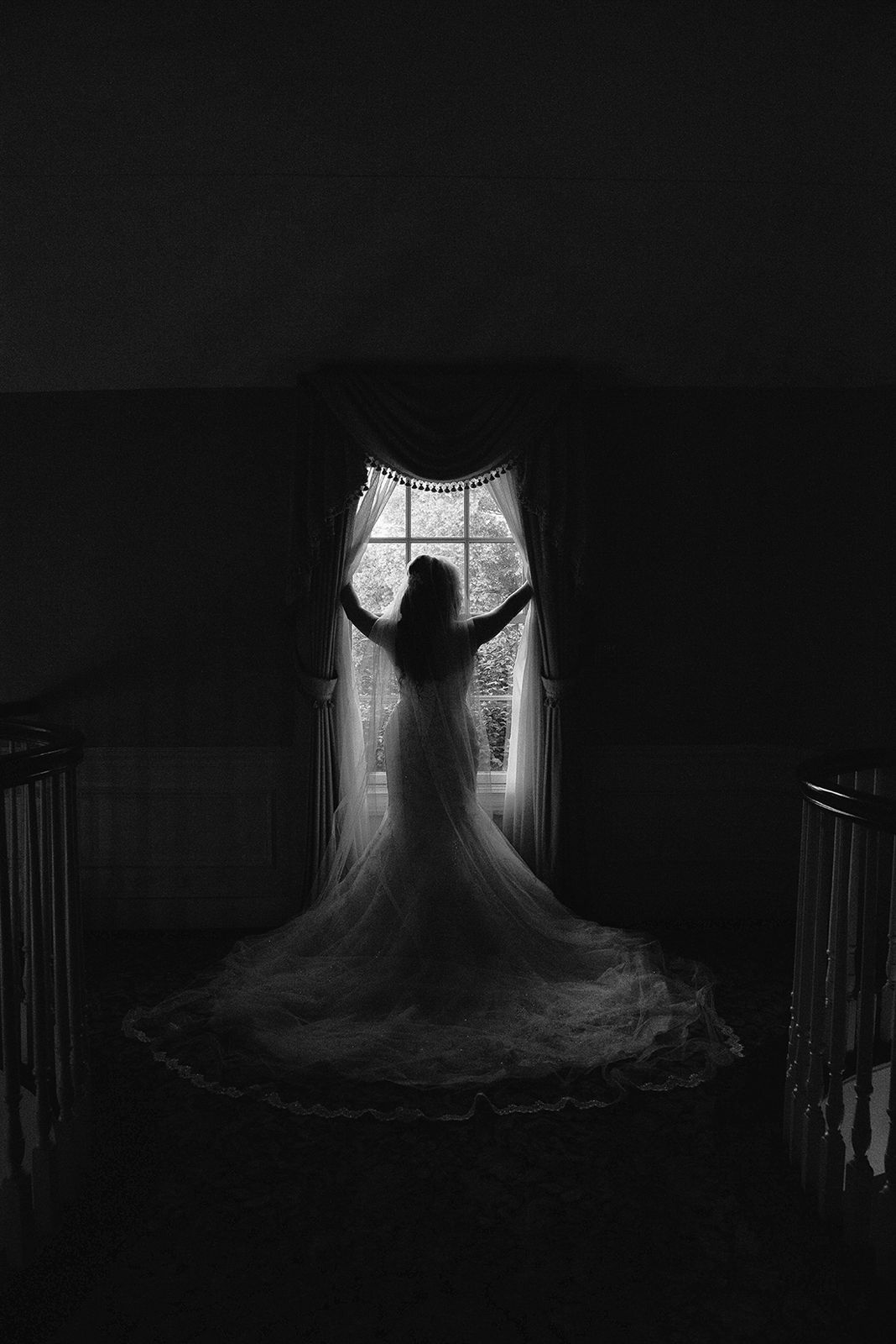Bride silhouetted against a tall window at The Royalton Mansion
