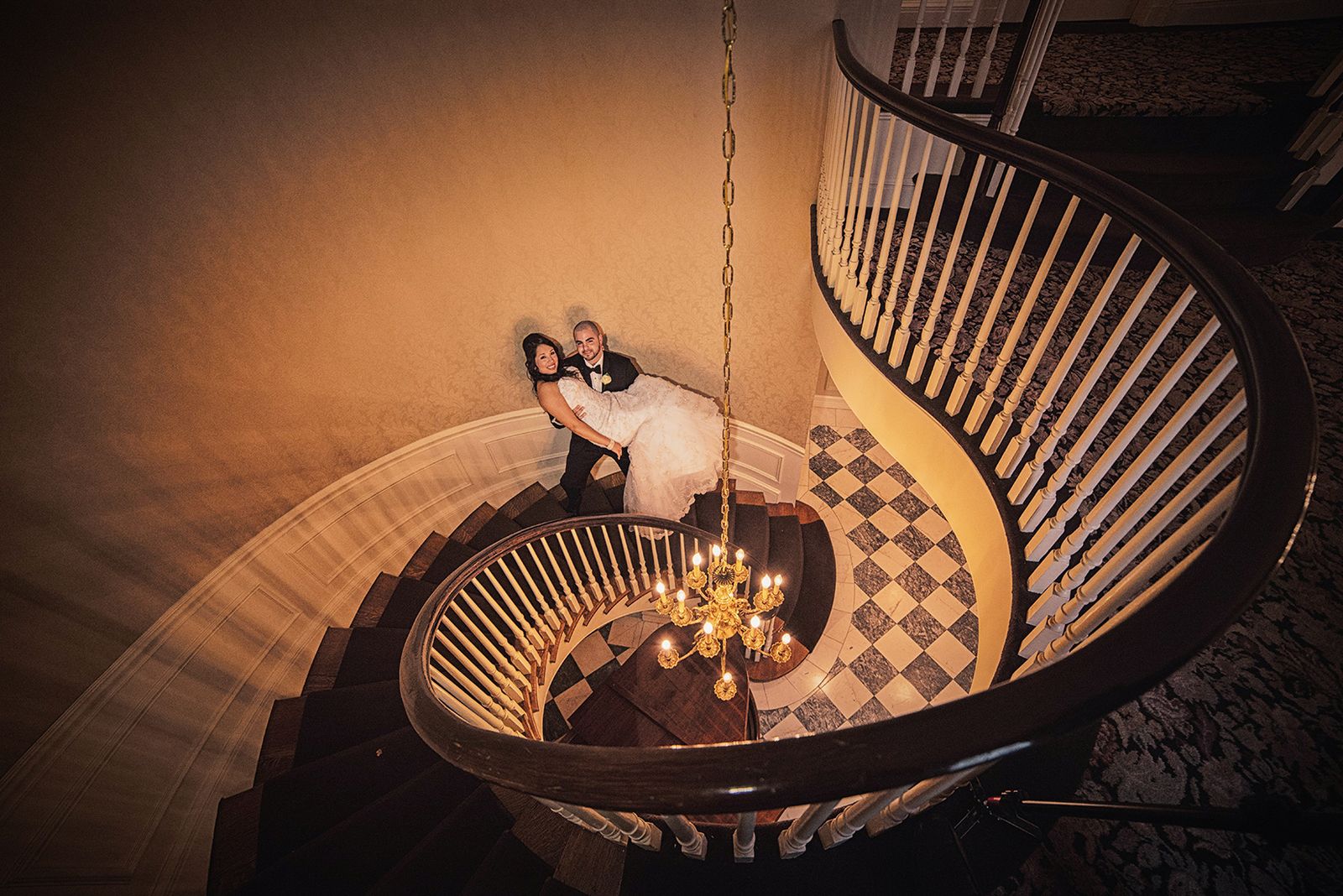 Bride and groom seen from above on the curved staircase at The Royalton Mansion