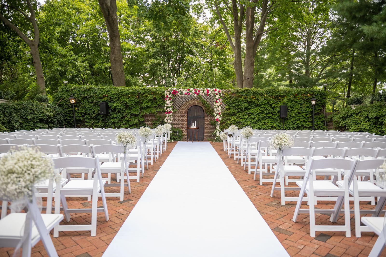 Garden ceremony aisle with floral arch at The Royalton Mansion