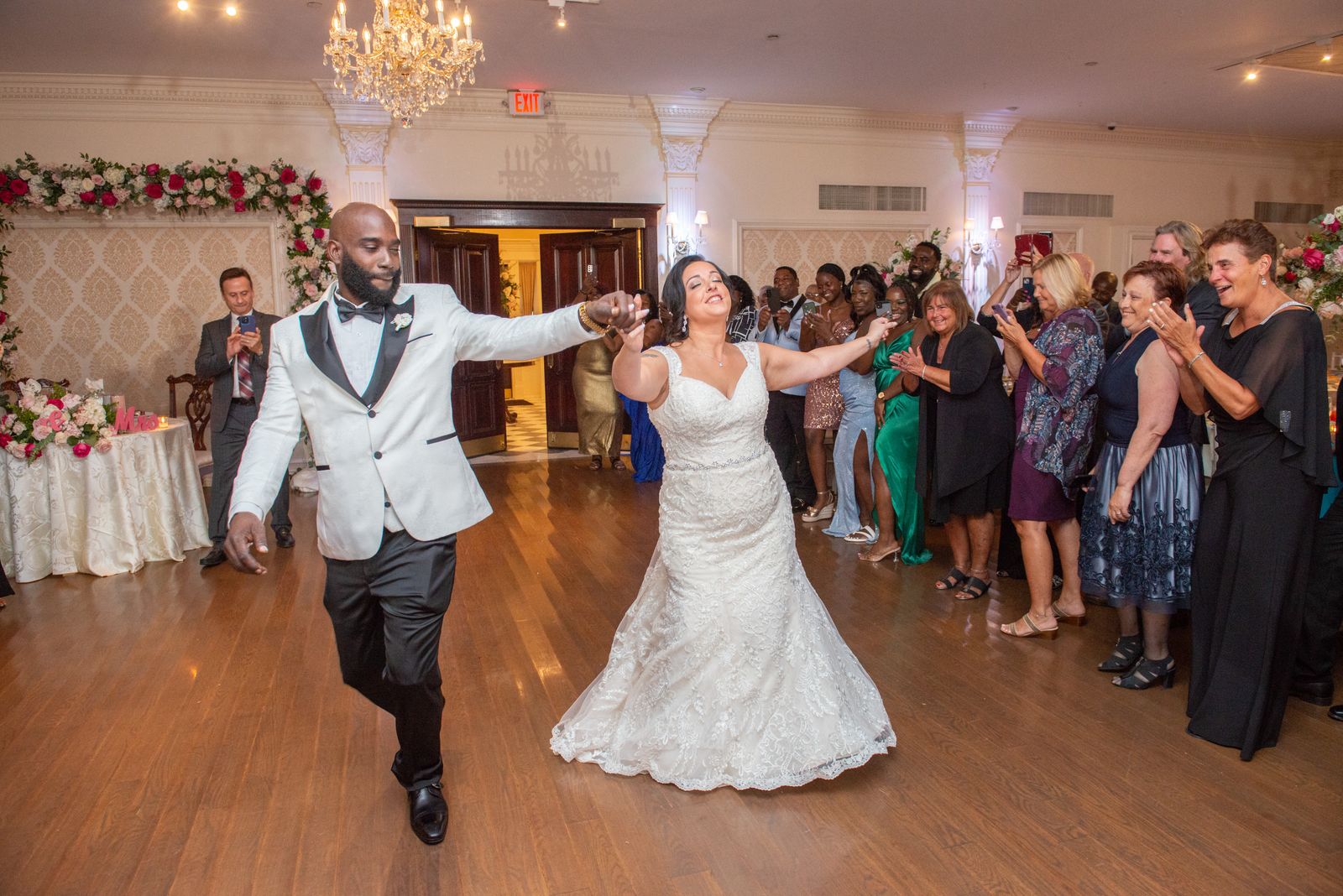 Bride and groom make their reception entrance as guests cheer at The Royalton Mansion