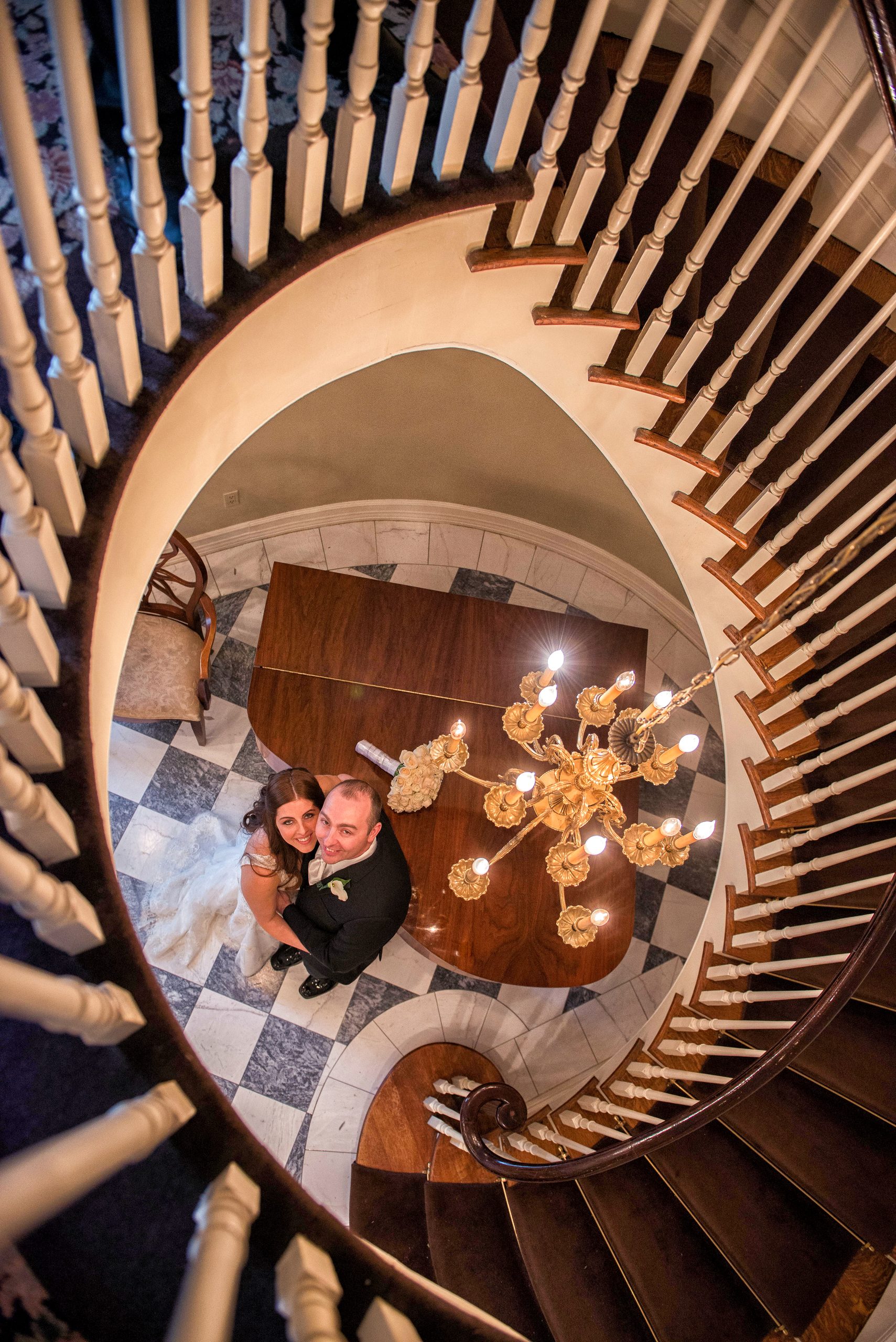 Bride and groom photographed from above the spiral staircase at The Royalton Mansion