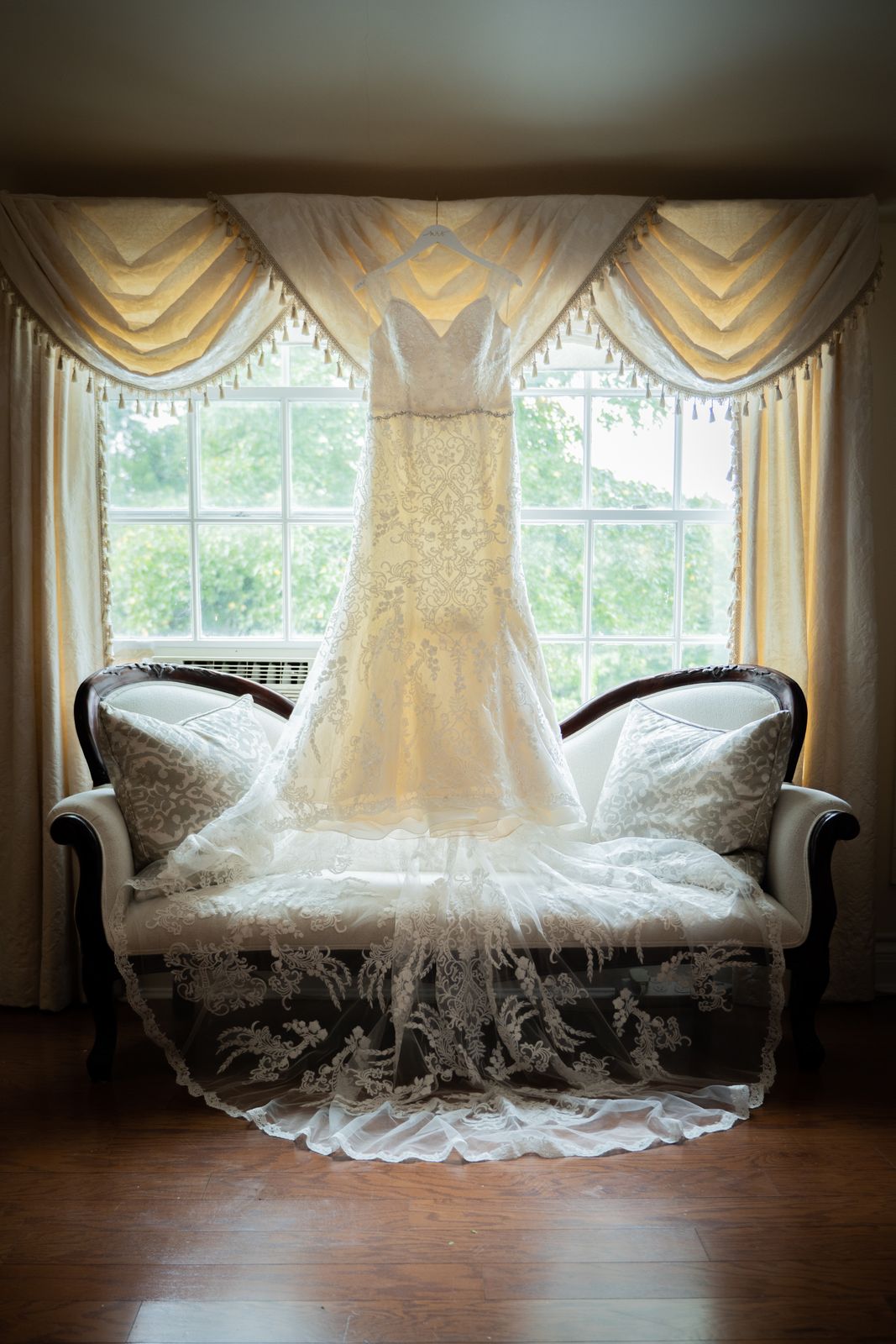 Wedding dress displayed on a settee in the bridal suite at The Royalton Mansion