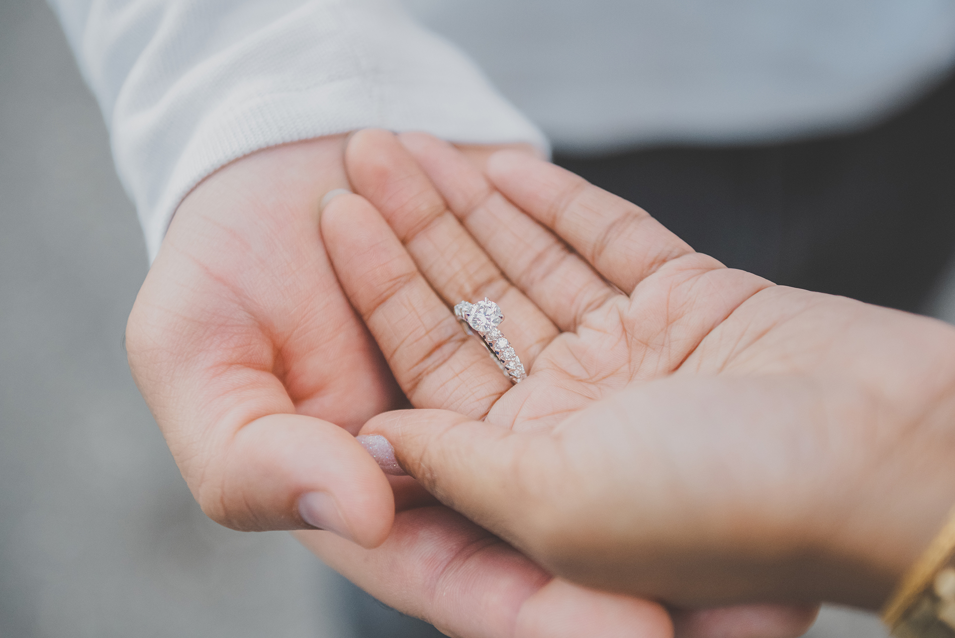Close-up of diamond engagement ring held in hands showcasing elegant jewelry detail during Hudson Valley engagement session
