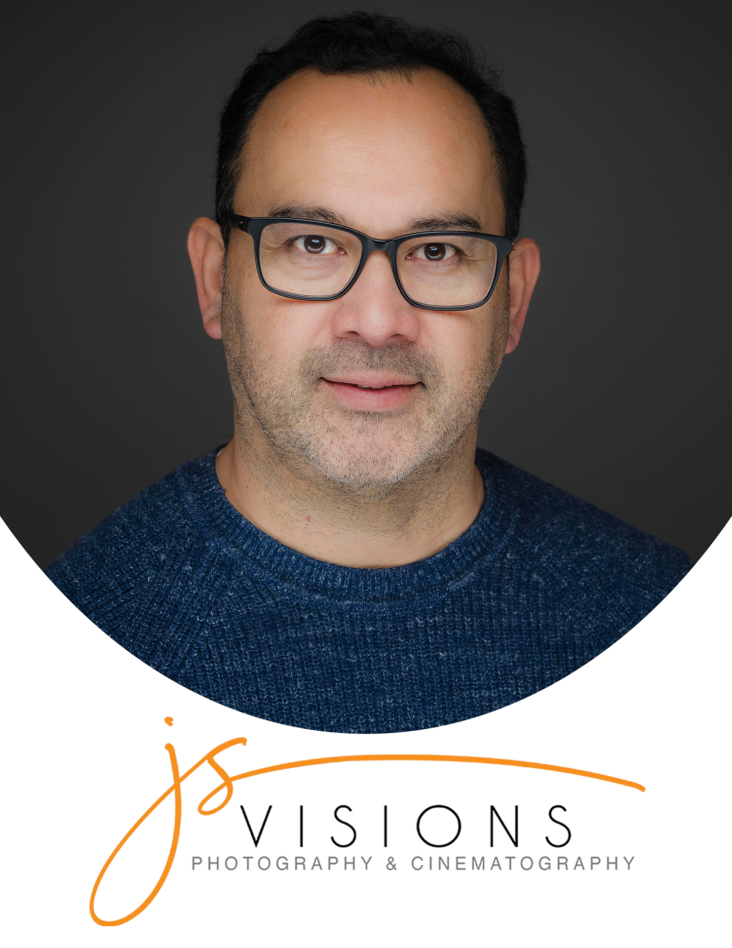Professional studio headshot of a man wearing glasses and a blue sweater photographed by JS Visions Photography & Cinematography in Long Island, New York