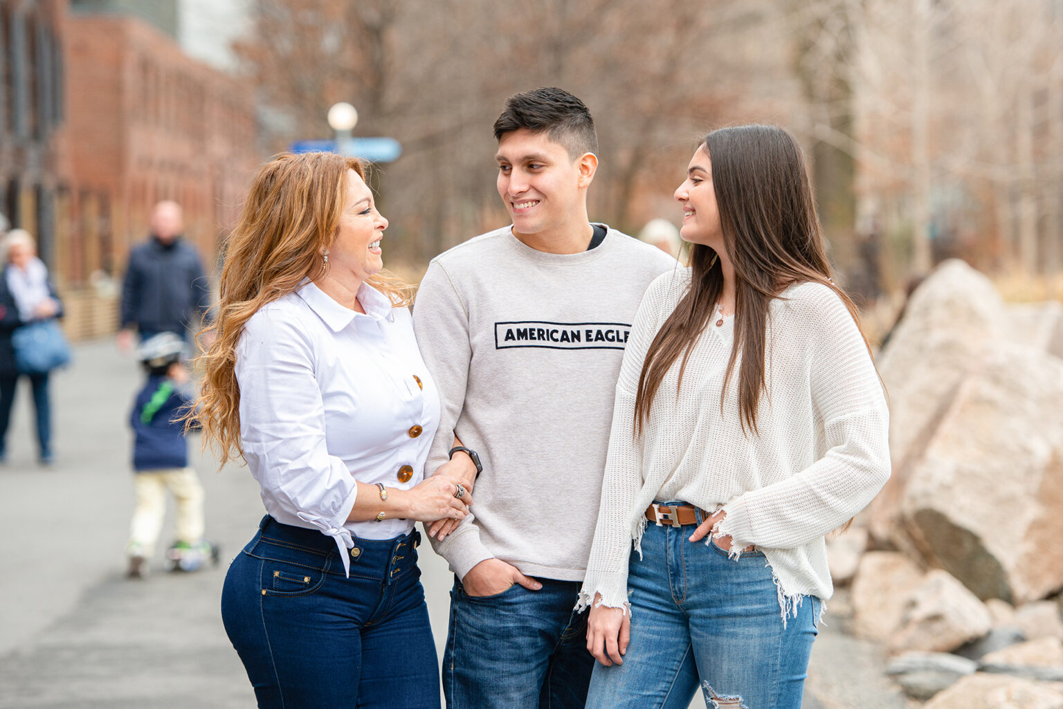 Mother laughing with her son and daughter during a candid outdoor family session in Brooklyn.