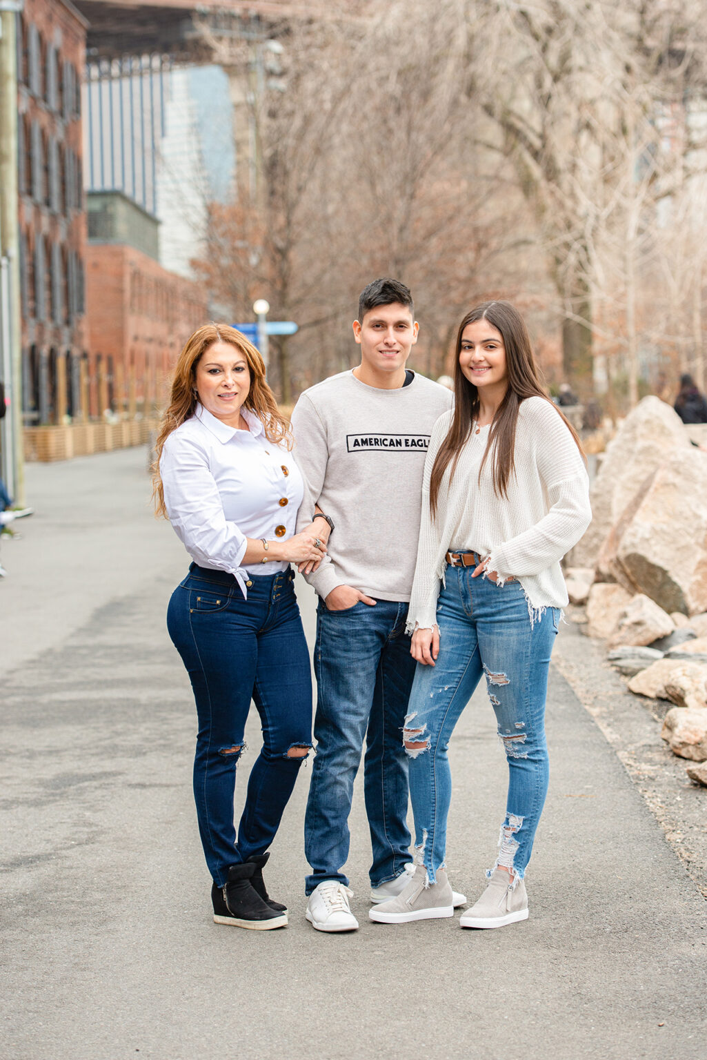 Mother posing with her adult son and daughter during an outdoor family portrait session in Brooklyn.