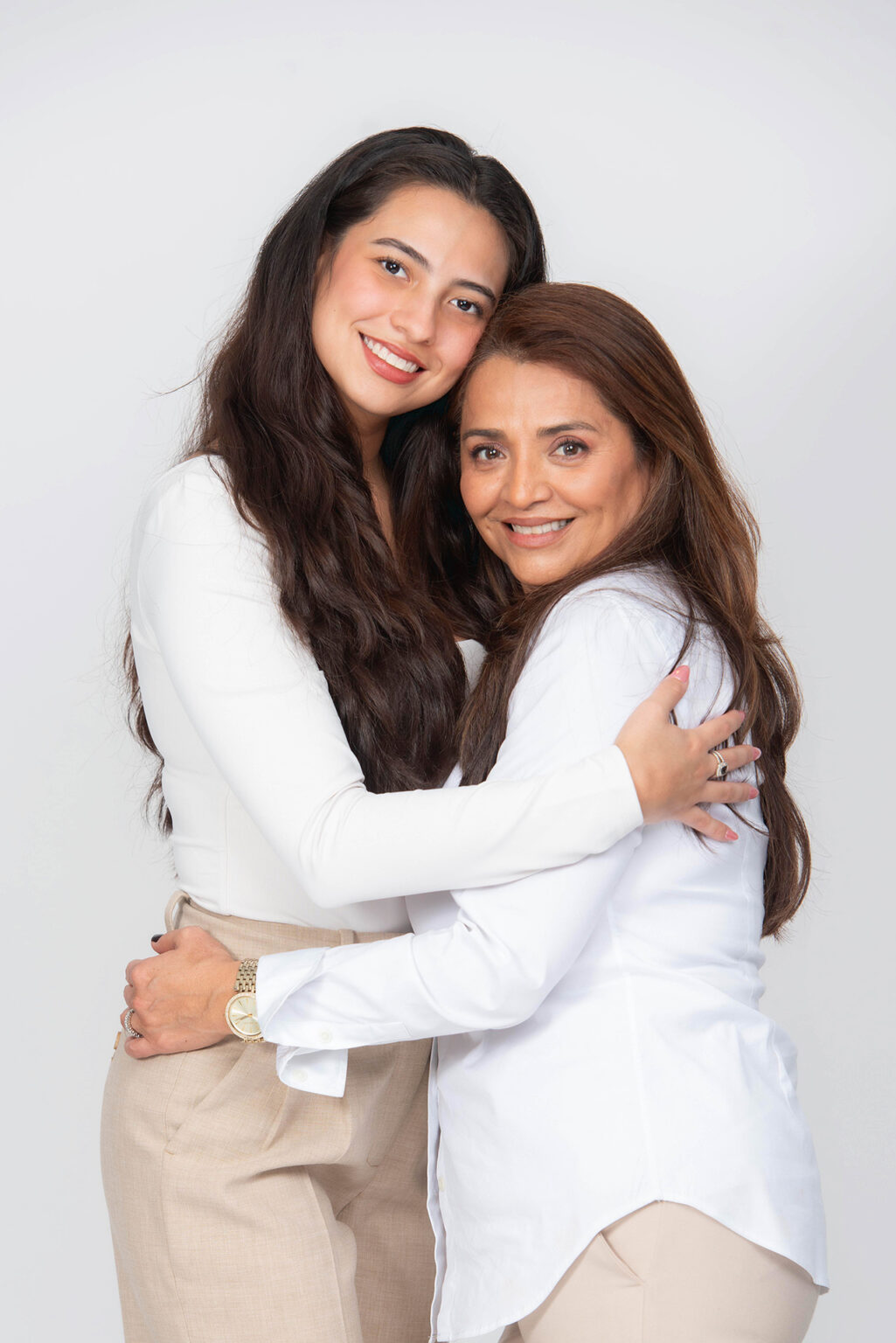 Mother and adult daughter smiling and embracing during a professional studio family portrait session on Long Island.
