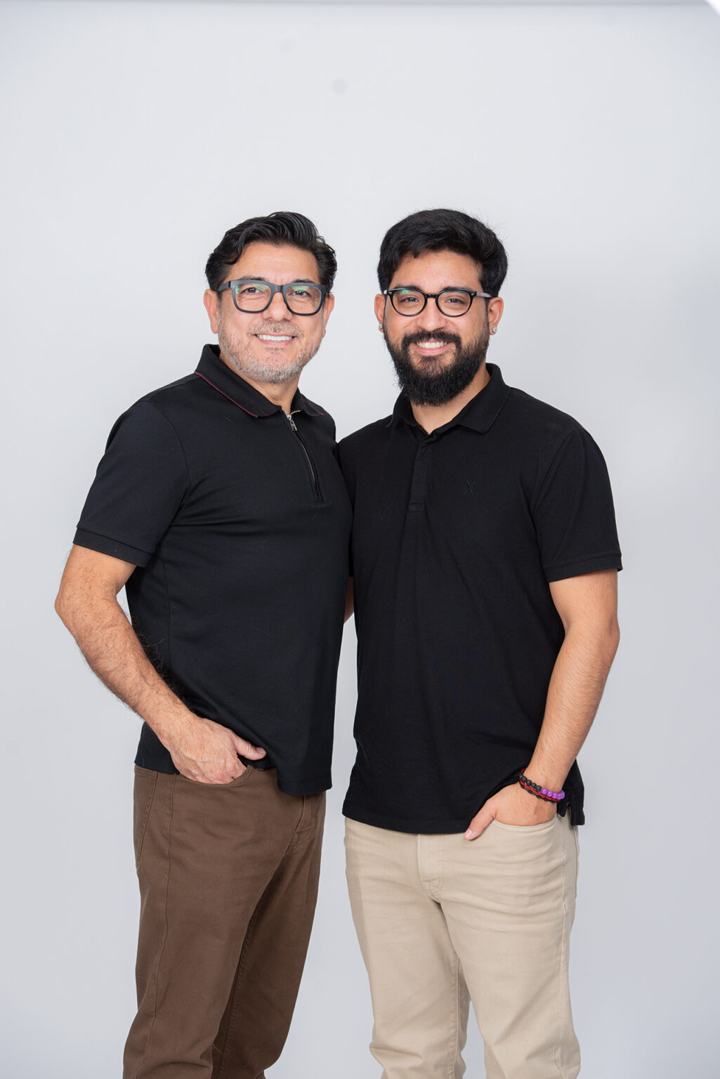 Father and adult son posing side by side in coordinated black shirts during a Long Island family photography session.