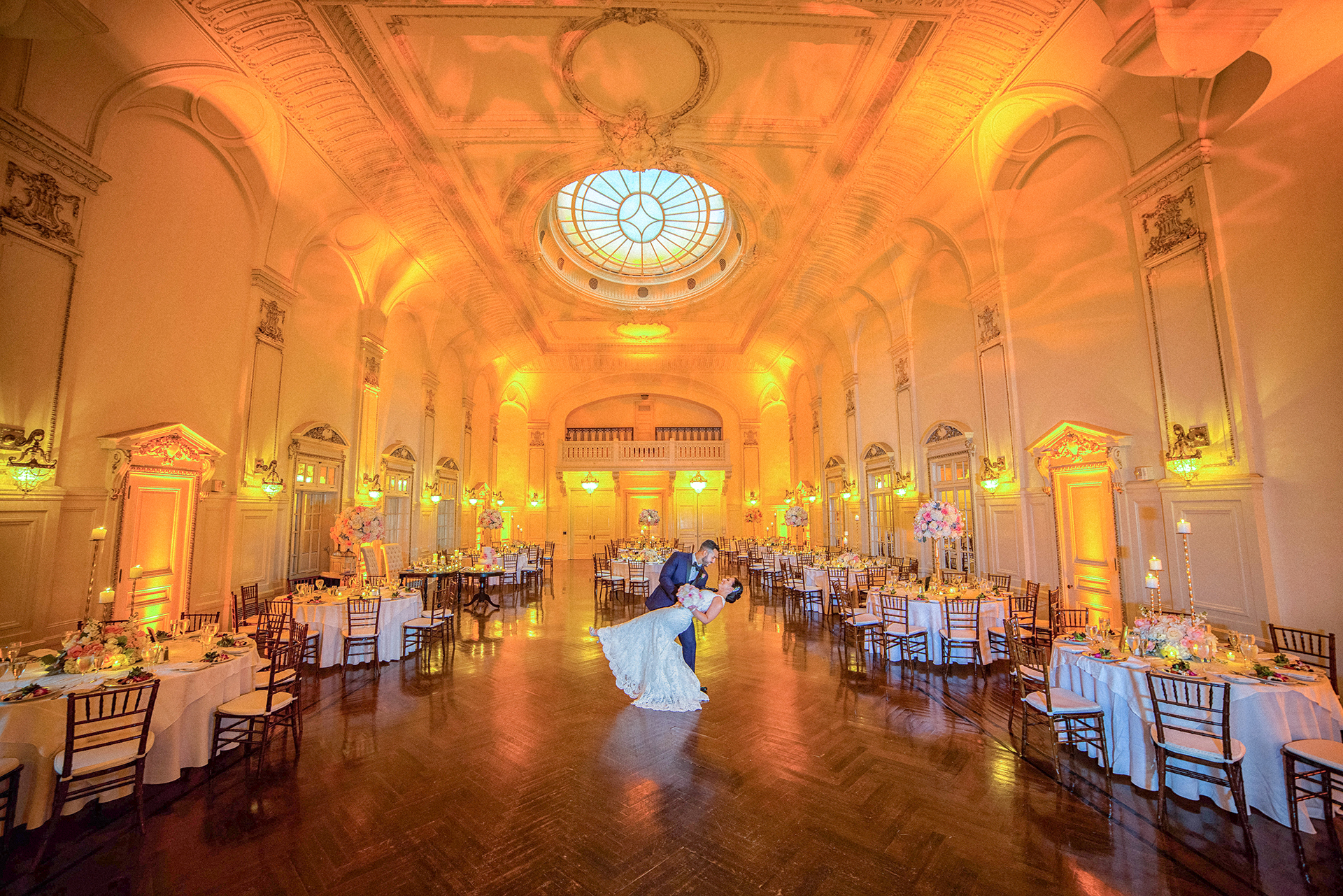Bride and groom sharing a romantic dip in the grand ballroom at Bourne Mansion during their Long Island wedding reception.
